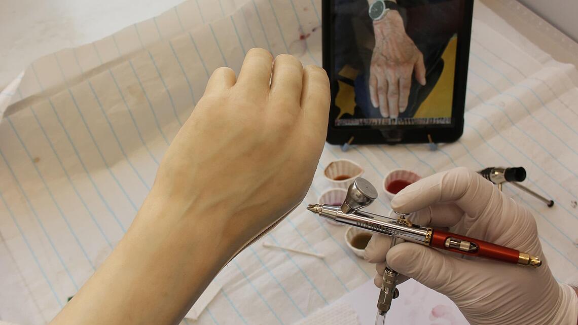 Airbrush-Arbeiten an Unterarmprothese mit Fotovorlage des realen noch vorhandenen Arms