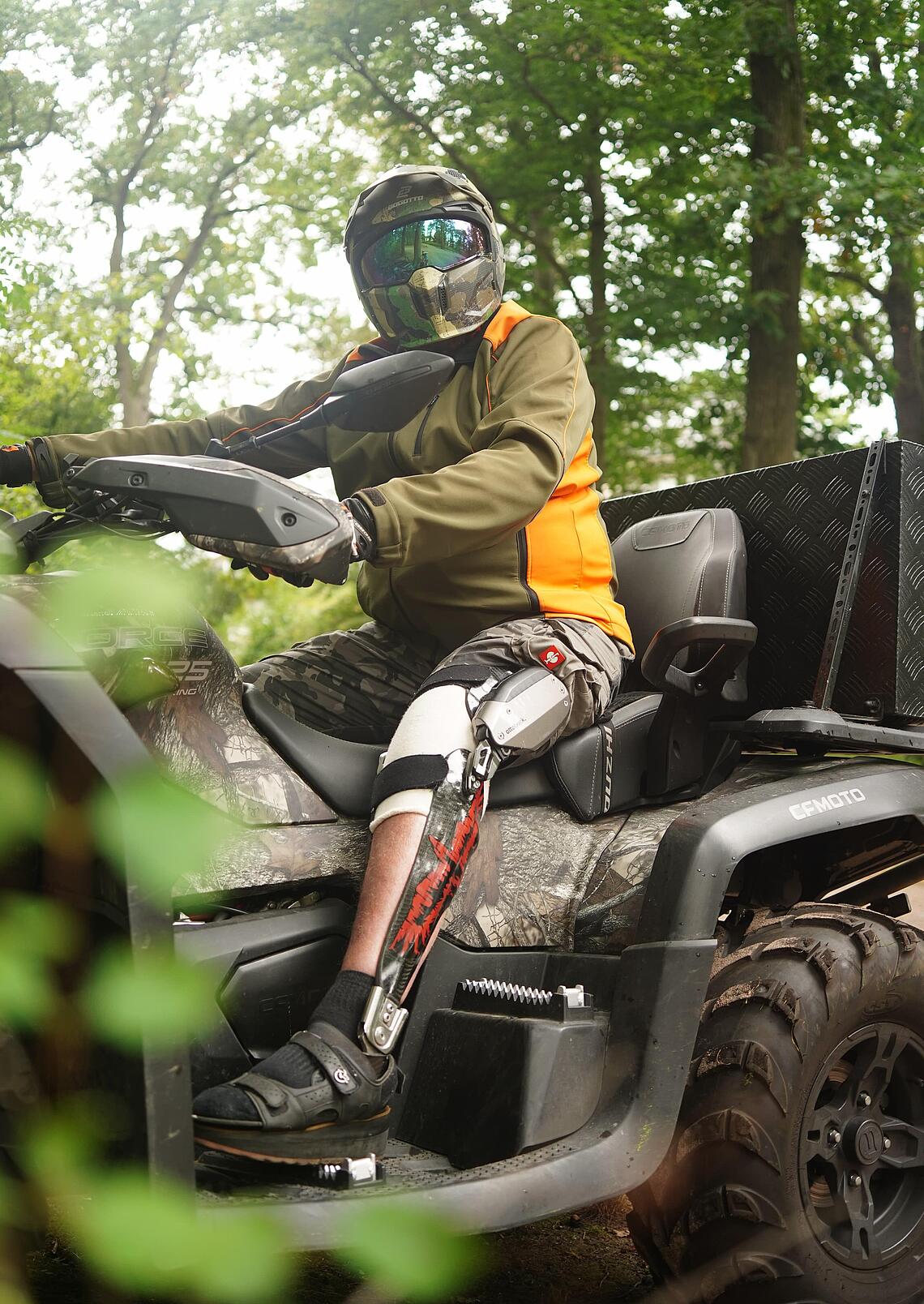 Quadfahren mit einer C-Brace-Versorgung Patient mit einer C-Brace-Versorgung sitzt im Wald auf einem Quad