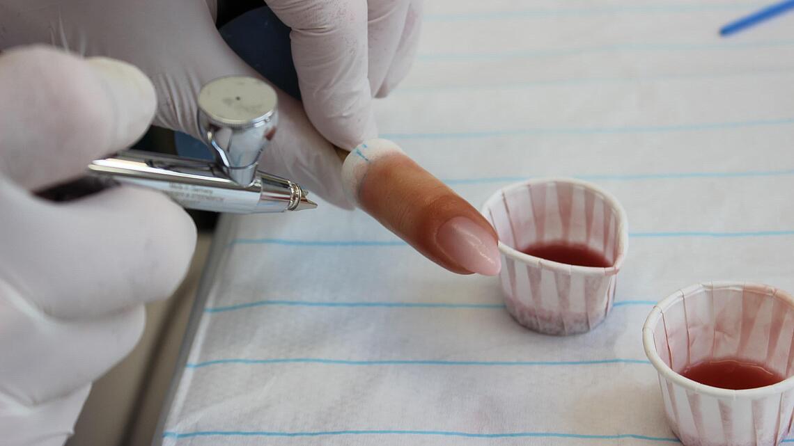 Airbrush-Pistole mit entsprechenden Farbtöpfchen zur Färbung einer Fingerprothese