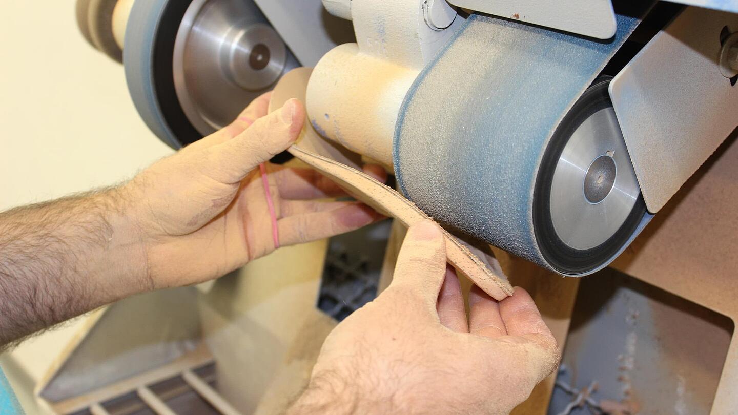 eine Einlage wird im Rahmen der Fertigung geschliffen, um Ecken und Kanten zu entfernen