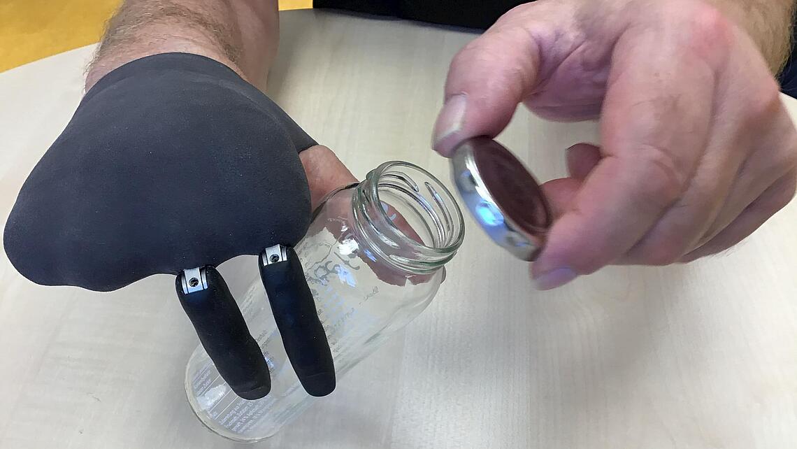 Teilhandprothese, die eine Flasche zum Öffnen hält