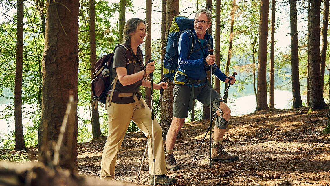 Waldwanderung mit Knieorthese Unloader One X, © Copyrights by Össur hf Wanderung im Wald mit Mann mit Knieorthese Unloader One X und Stöcken, © Copyrights by Össur hf