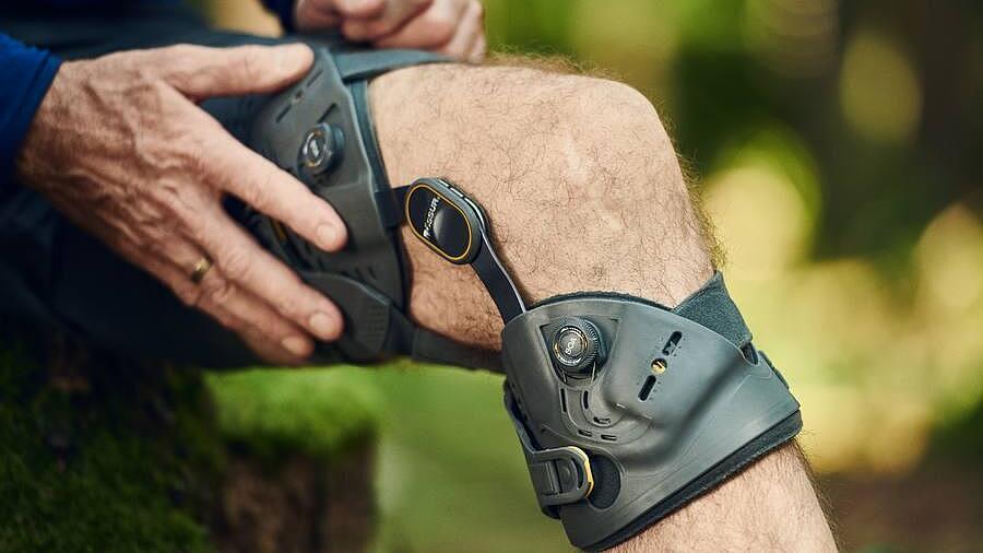 Orthese Unloader One X von Össur am Knie, © Copyrights by Össur hf Knie-Orthese Unloader One X von Össur; Mann fässt an die Orthese, © Copyrights by Össur hf