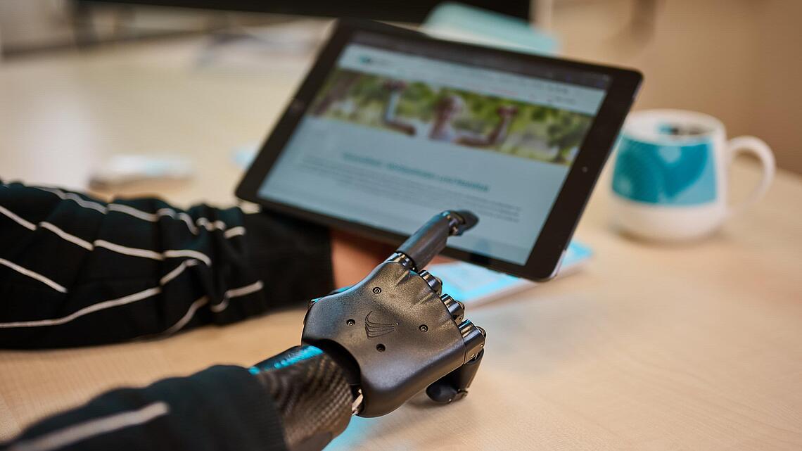 schwarze myoelektrische Armprothese zeigt auf Tablet, Quelle: newpic photography