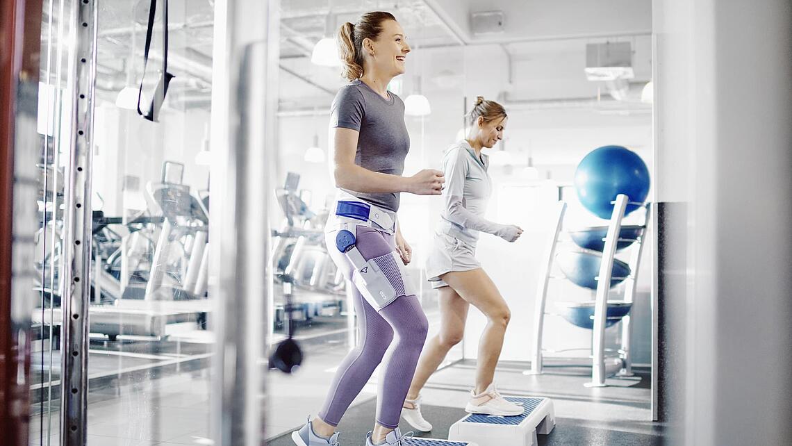 Frau mit Hüft-Orthese Coxa Train beim Sport, Quelle: Bauerfeind AG, Zeulenroda Frau mit Hüft-Orthese Coxa Train beim Sport auf dem Step-Brett, Quelle: Bauerfeind AG, Zeulenroda