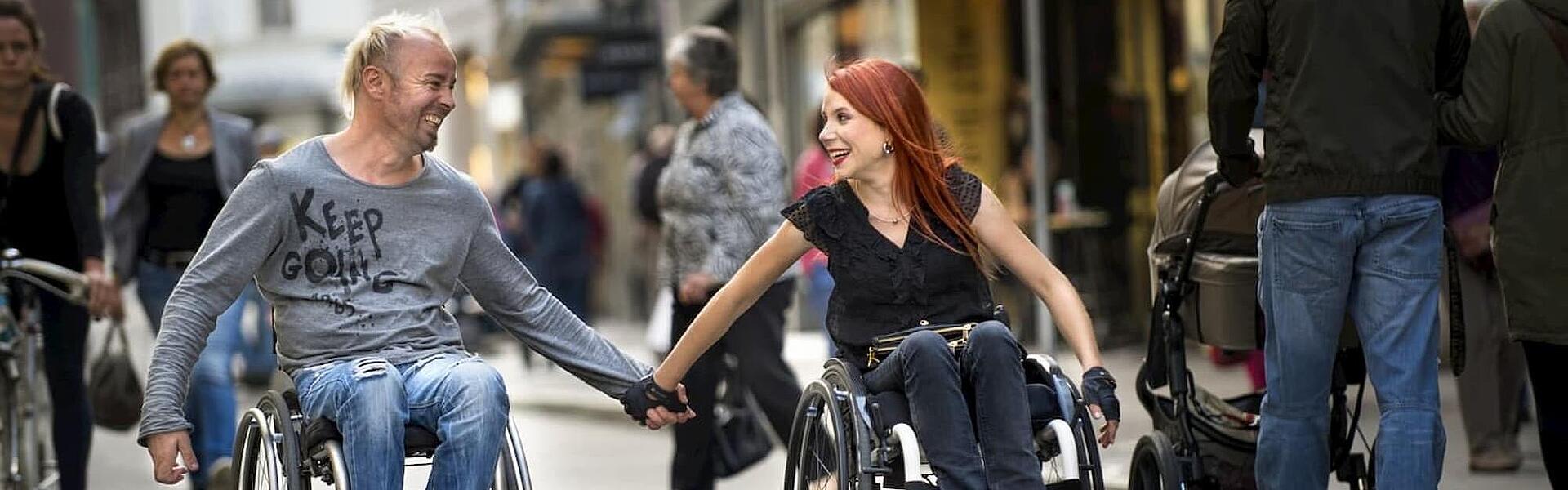 glückliches Paar die händehaltend im Rollstuhl sitzen, ©Invacare glückliches Paar aus Mann und Frau, die händehaltend im Rollstuhl sitzen, ©Invacare