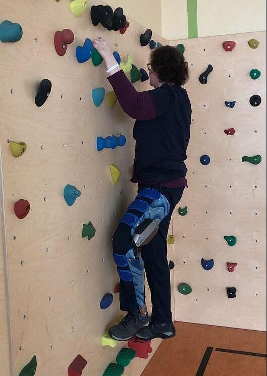 C-Brace-Anwenderin an Kletterwand C-Brace-Anwenderin klettert eine Wand hinauf