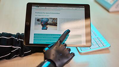 Finger-/Handprothese zeigt auf Tablet mit der ORD-Website